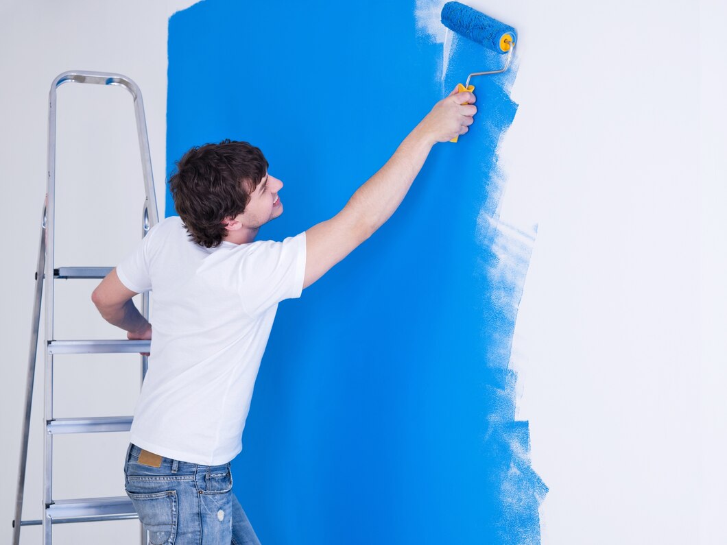 handsome-young-man-painting-wall-blue_186202-2045